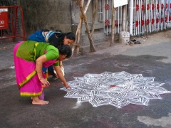 Women drawing an intricate kolam at Mylapore